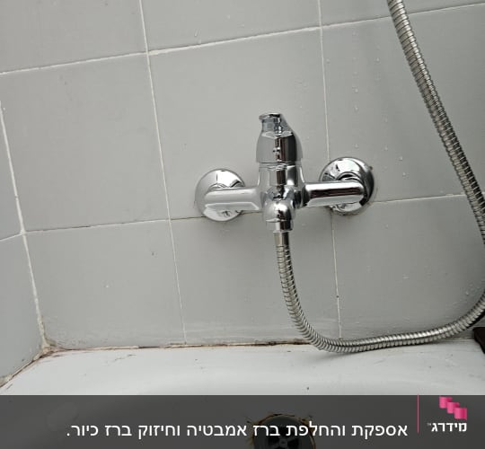 ברז אמבטיה עם צינור מתכת מחובר לקיר